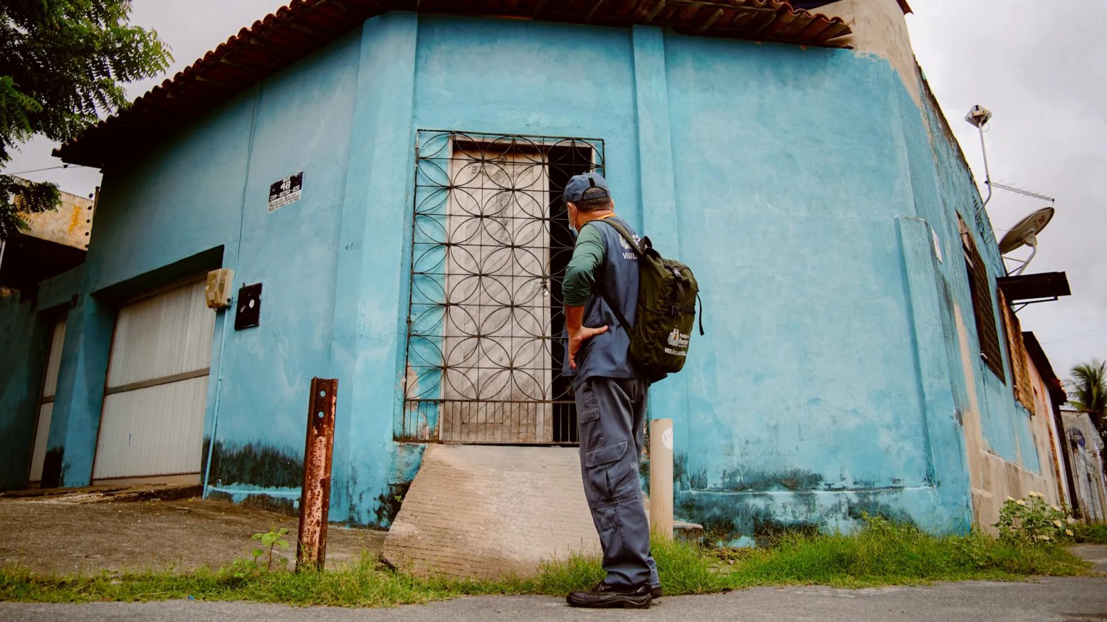 agente de saúde na frente de uma casa